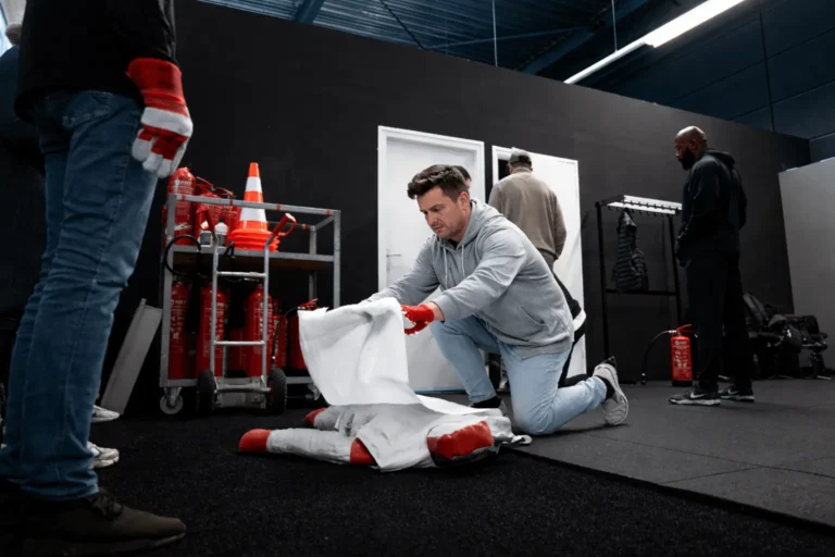 Cursist gebruikt branddeken bij slachtoffer tijdens BHV en EHBO training